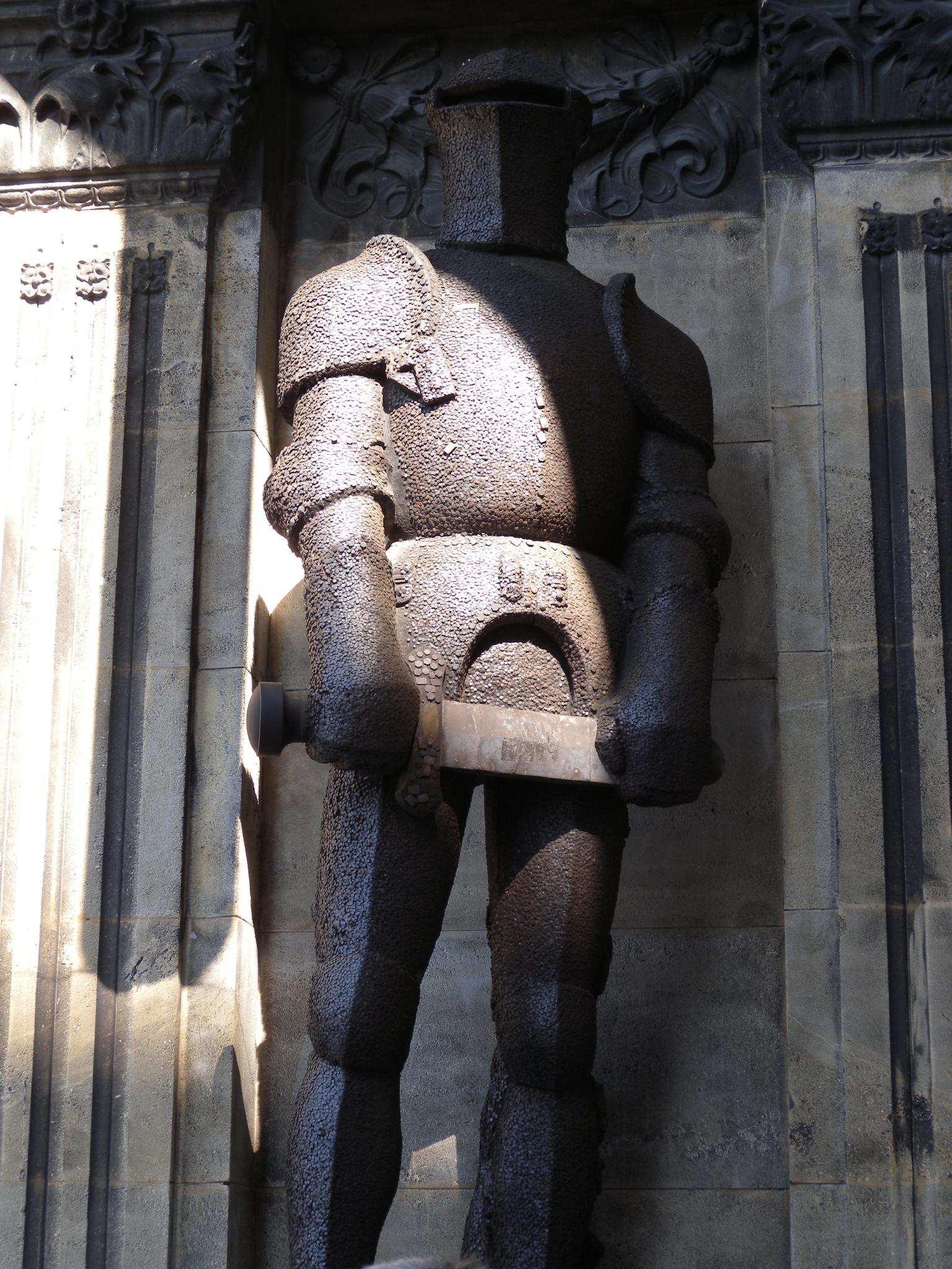 there is a statue of a man holding a piece of wood