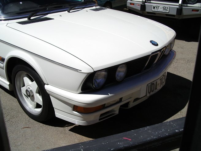 an image of a white car parked in the sun