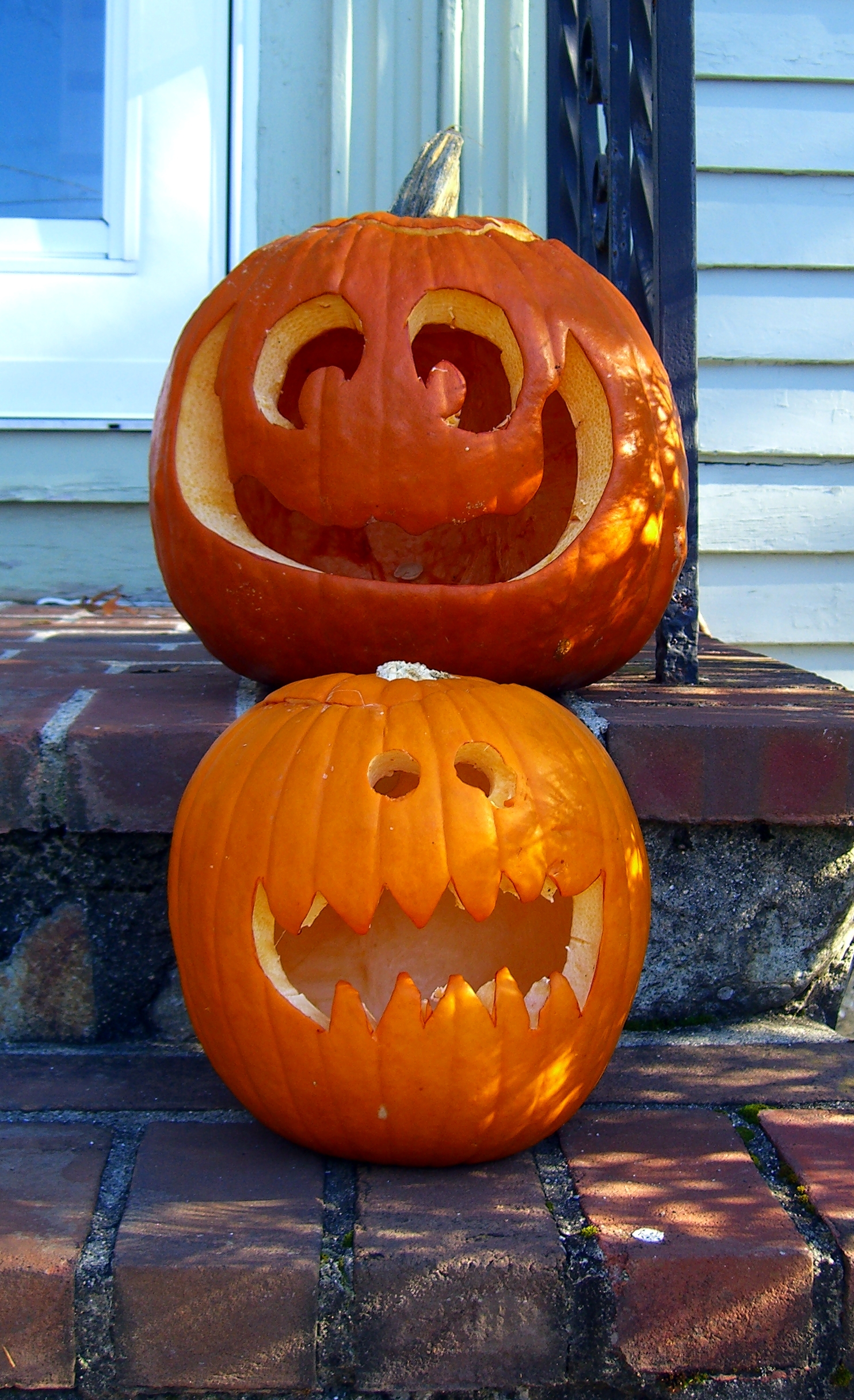 two carved pumpkins are sitting on the steps outside