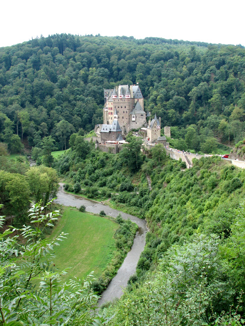 an image of a castle on a lush hill
