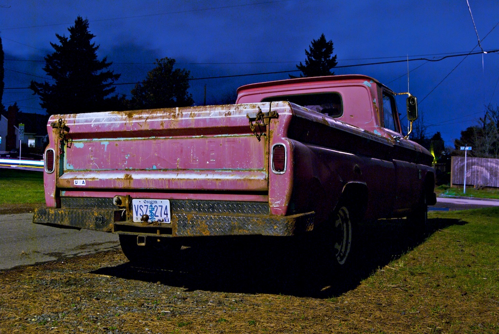 an old truck with a license plate parked in front of some homes