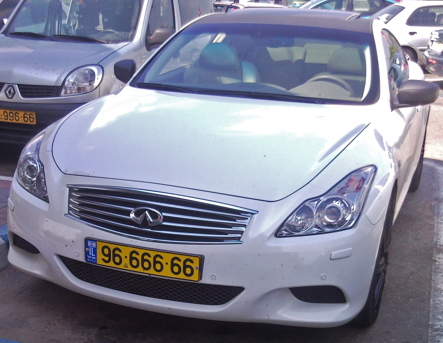 a white car is parked near some other cars