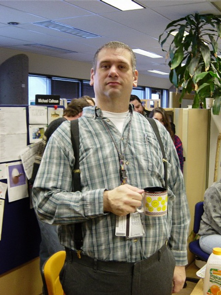 a man holding a coffee mug in an office