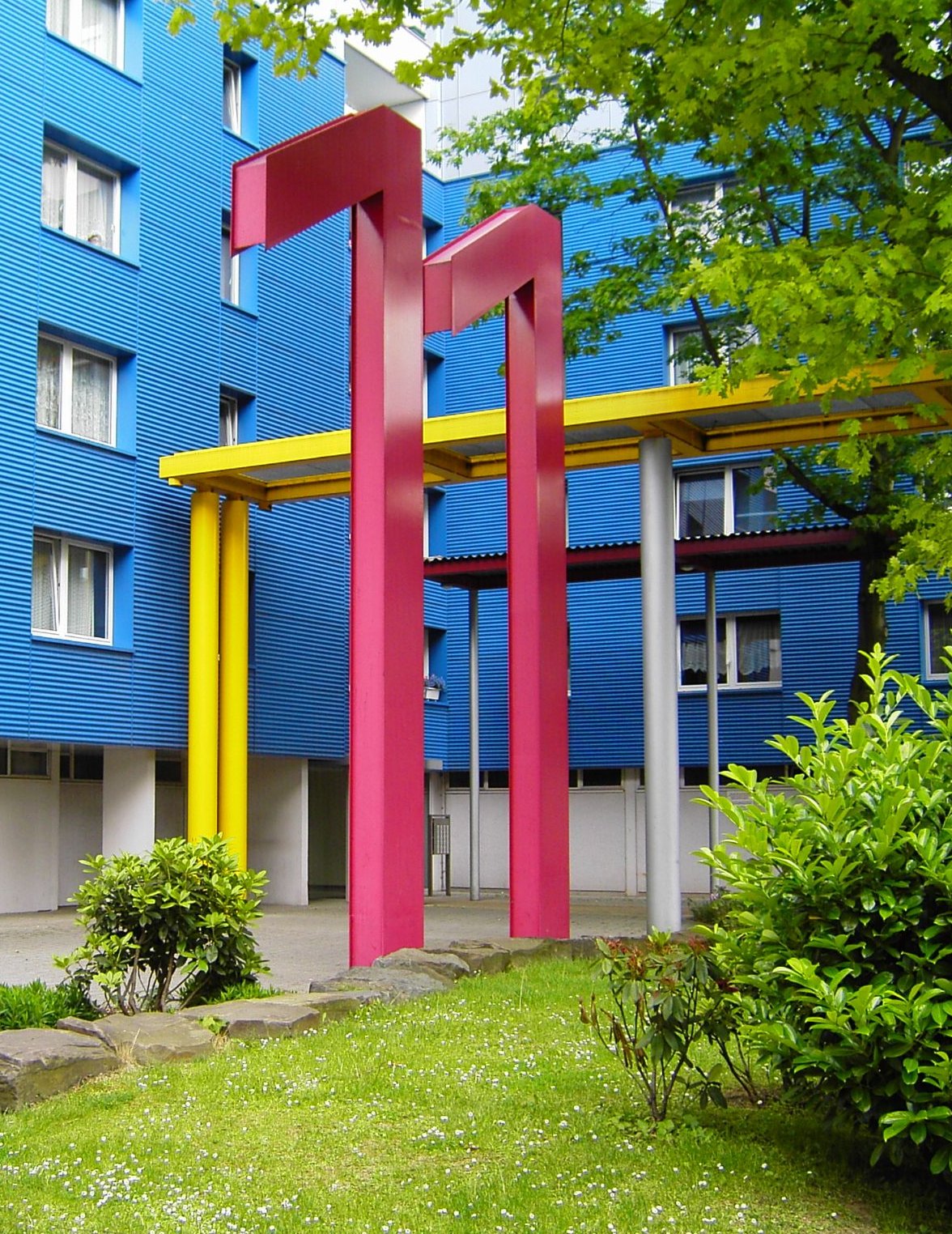 the front entrance to a building with red, yellow, and blue columns
