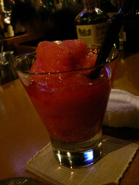 a watermelon drink sits on the table in a bar