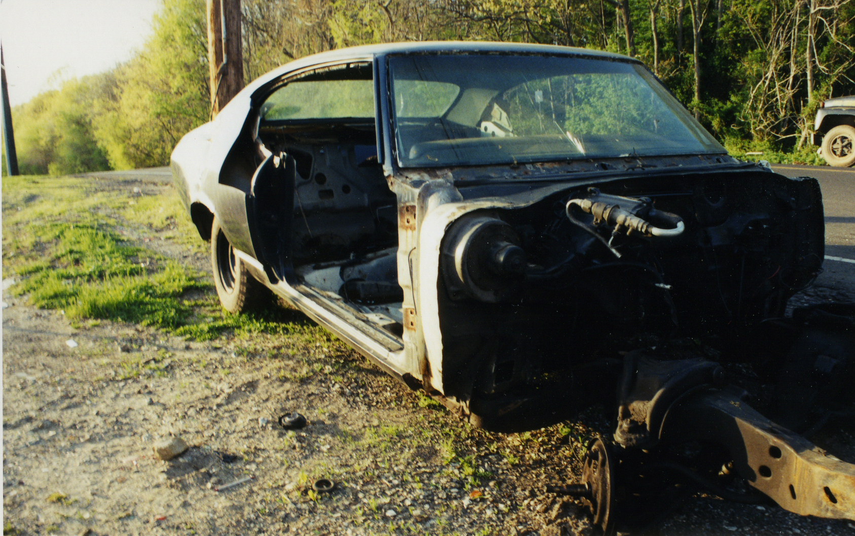 an old burned down, rusty car with the hood up