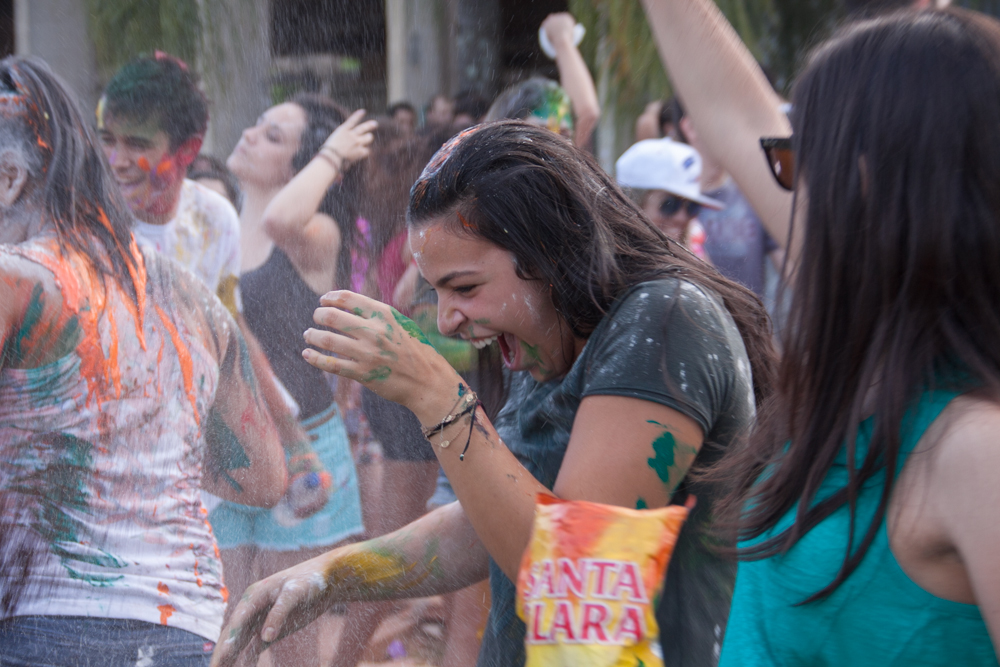 people are having fun, and colored water sprayed over them