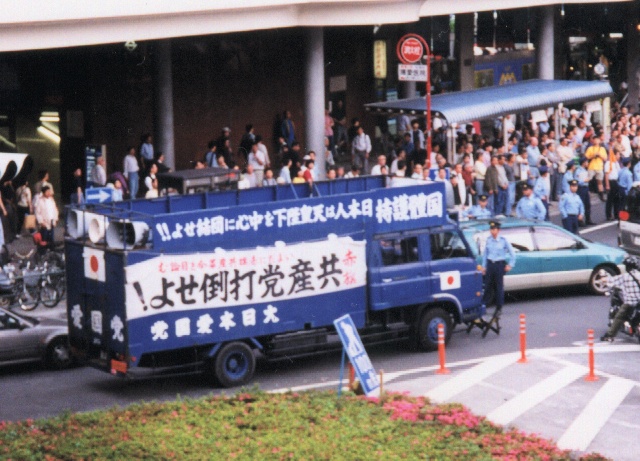 a blue truck is carrying asian characters with passengers