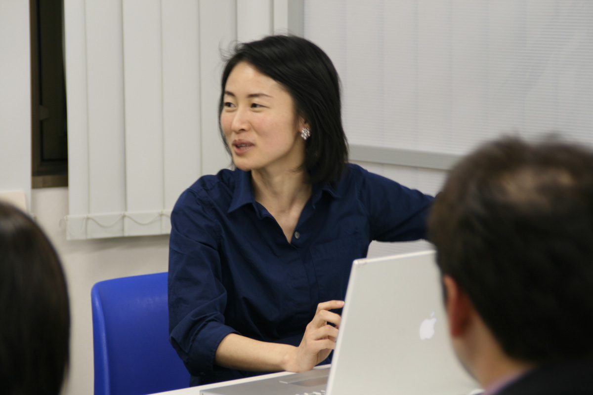 a woman sitting at a desk in front of a laptop