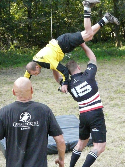 one man doing a backflip while holding another man
