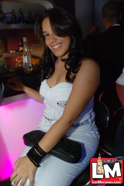 a girl wearing black heels sitting at a bar