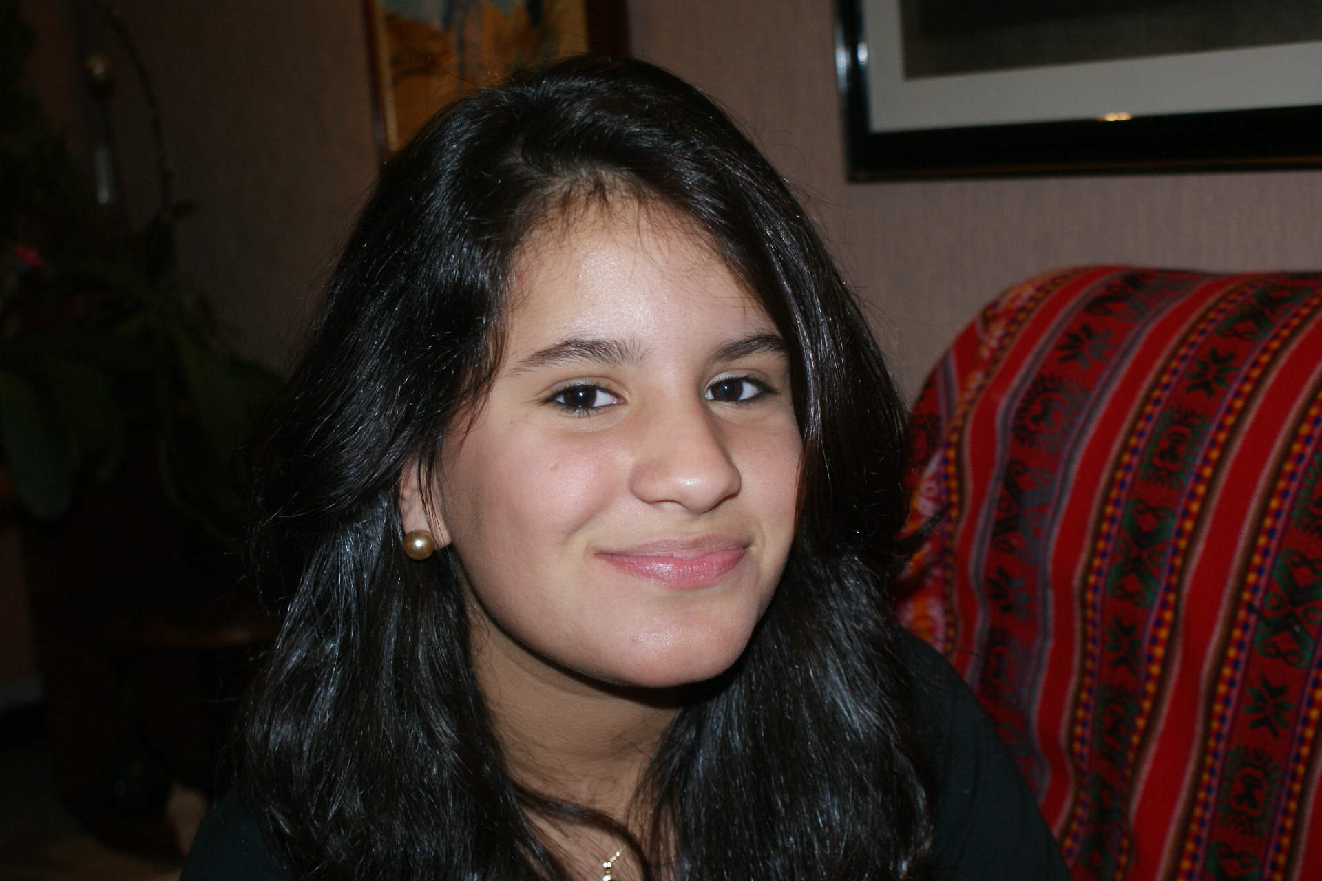 a woman sitting in front of a red couch