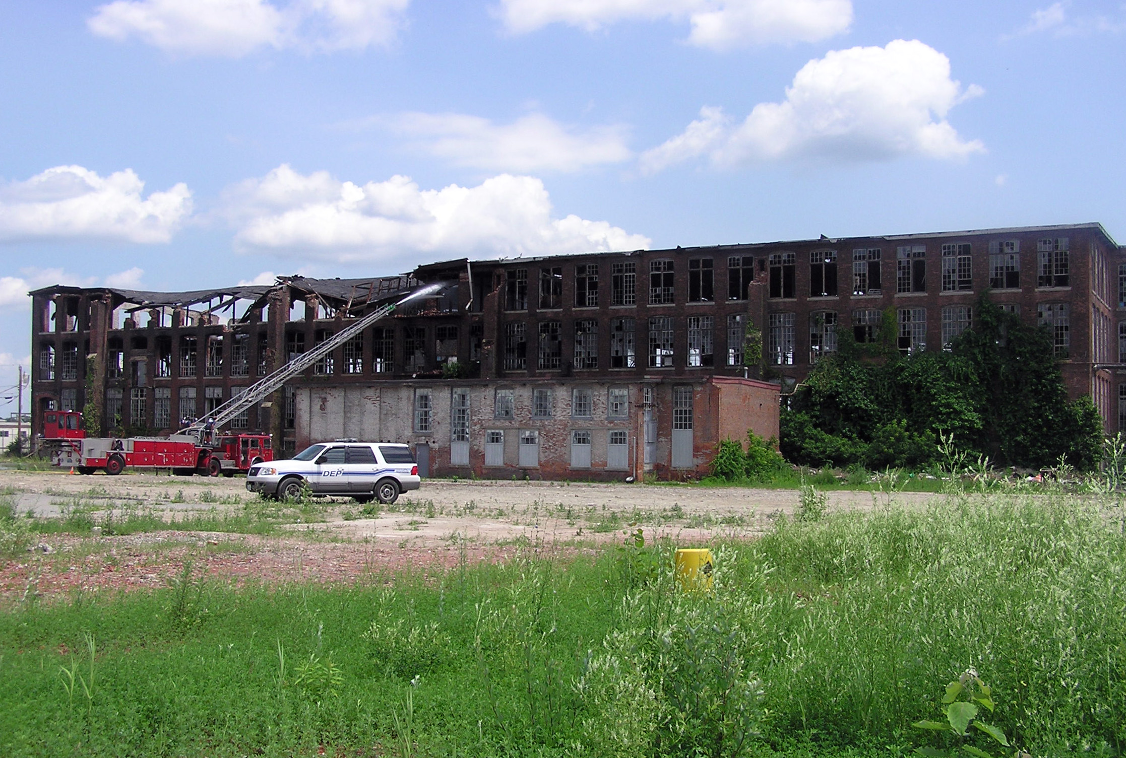 a fire truck is parked in front of a large burned out building