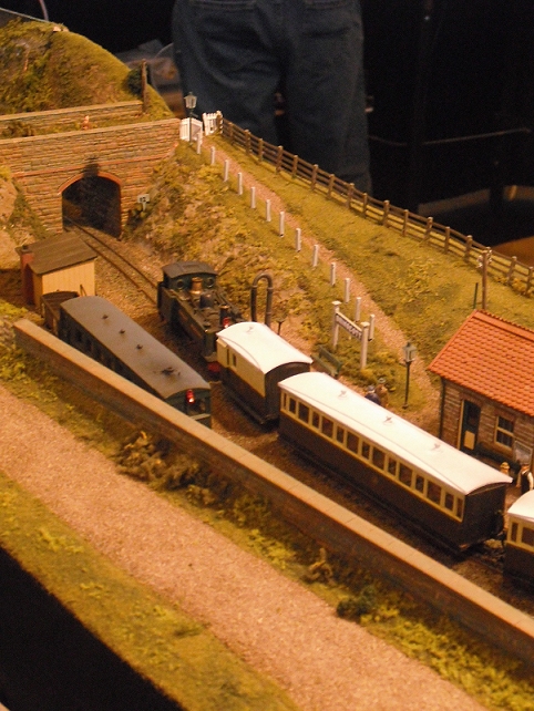 an assortment of model train sets sitting next to a model town
