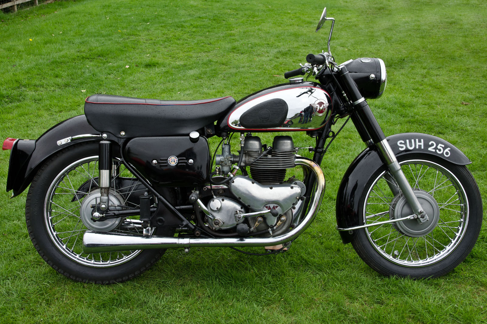 a vintage motorcycle parked on a field of grass