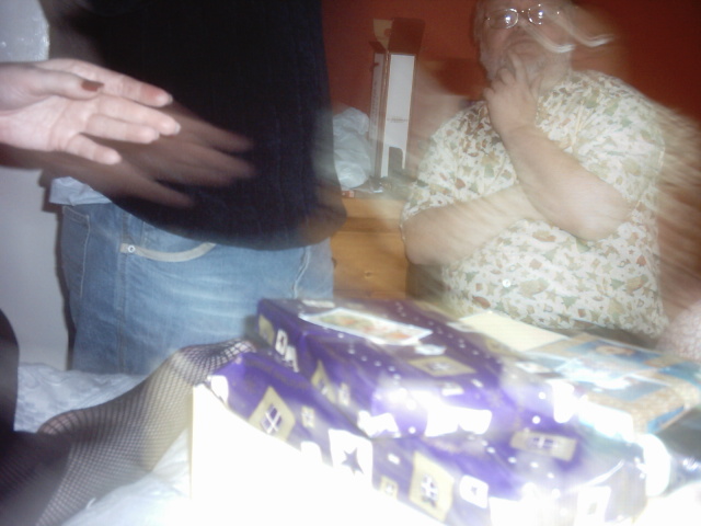 blurry image of man standing over a cake and a gift box