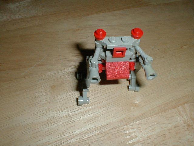 a toy robot made with lego parts sitting on the floor