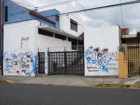 a large white house with blue graffiti on the walls
