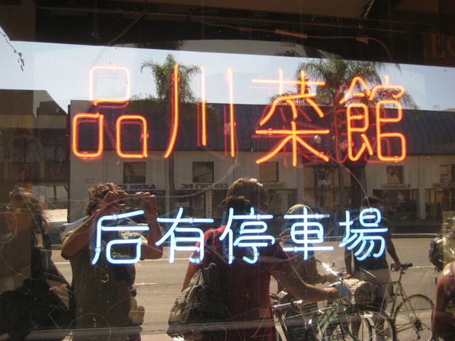 a lighted sign in a city window on the side of a building