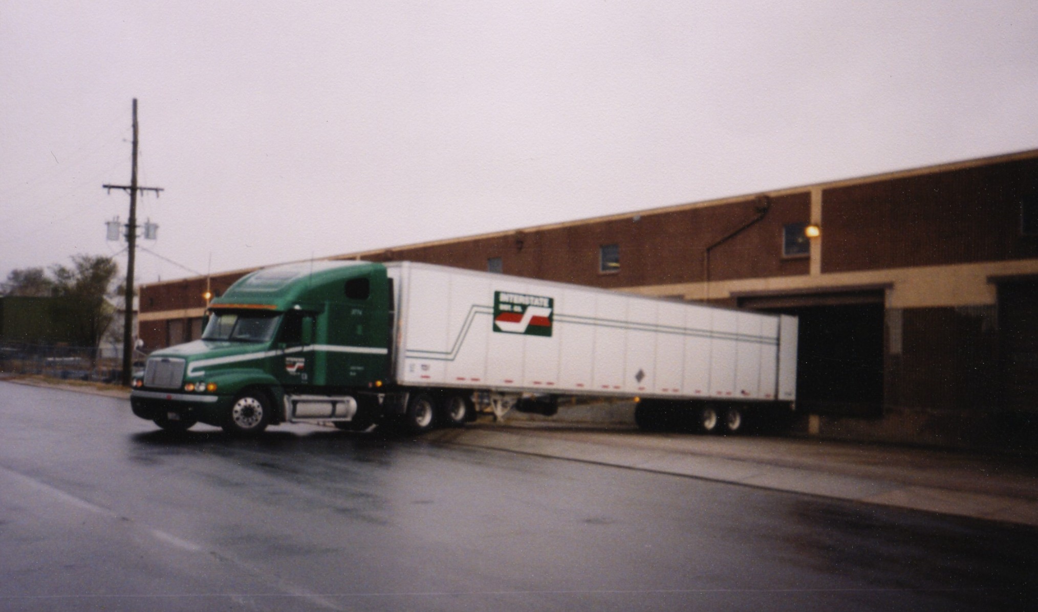 a semi truck pulling its trailer down the street