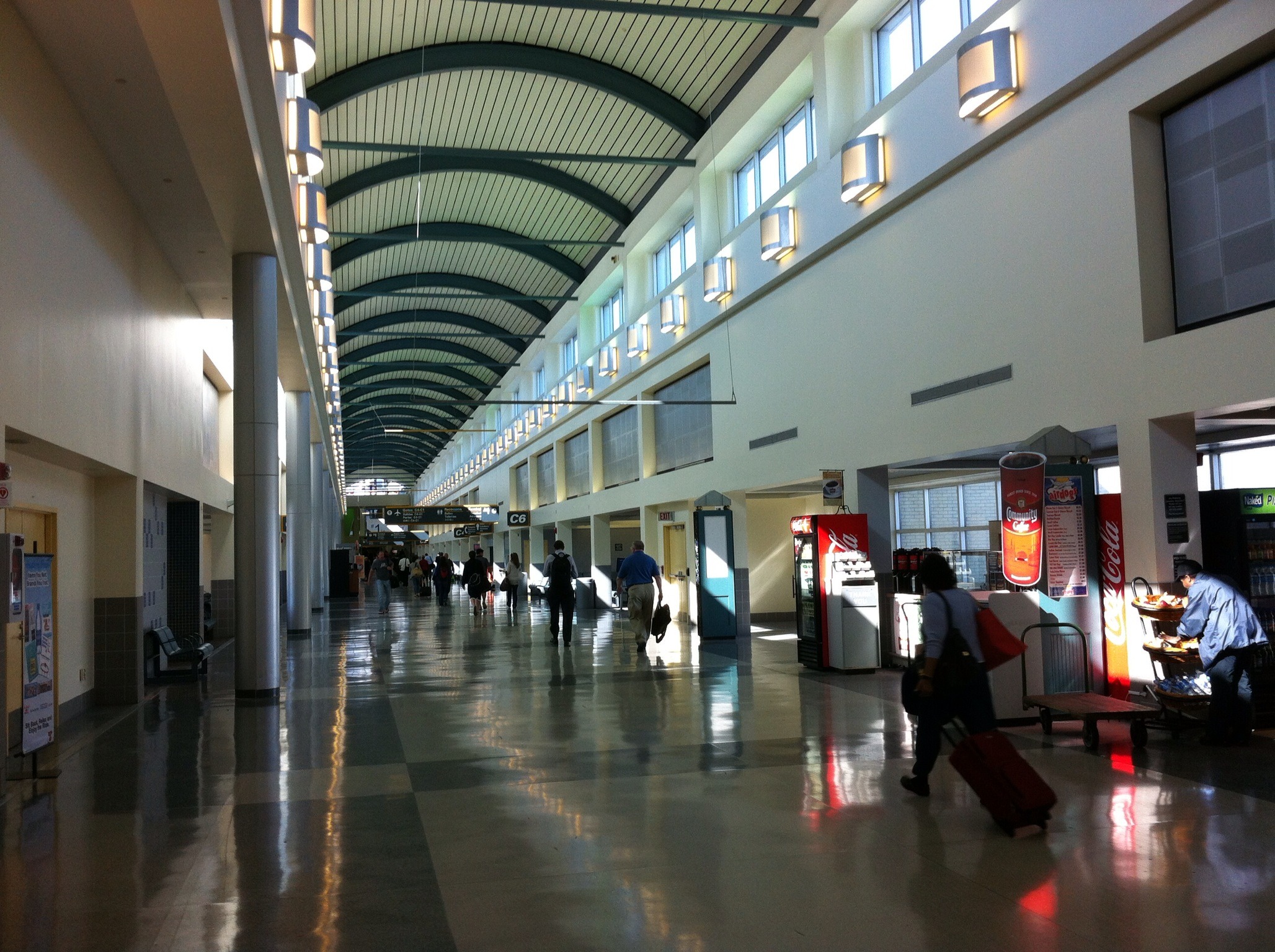 people are walking through the large terminal and walking along the walkway