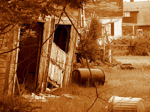 an old rundown farm yard and junkyard with rusted out metal equipment