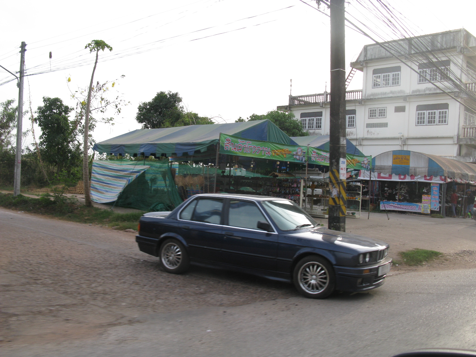 a black bmw e34 is parked in front of the buildings