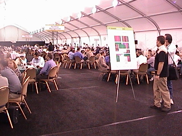 several people sitting in chairs in a large tent