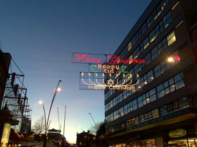 the neon signs hang from the buildings that advertise the holiday lights