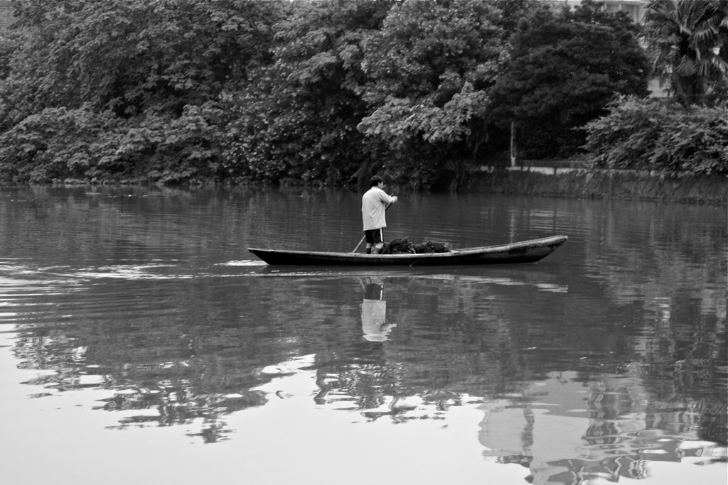 man on small boat in peaceful river area