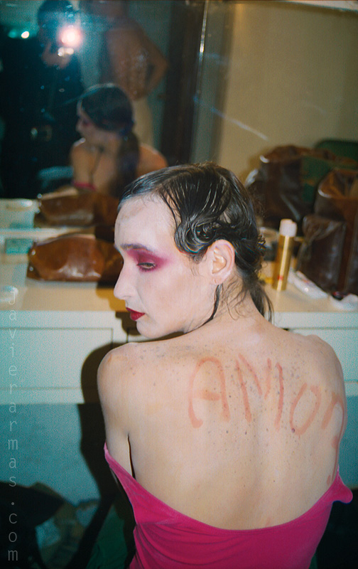 a women with pink and purple make up in a bathroom