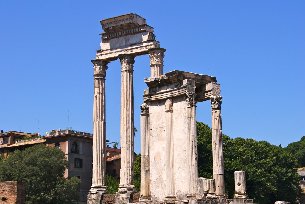 two pillars on the side of a river, next to some trees