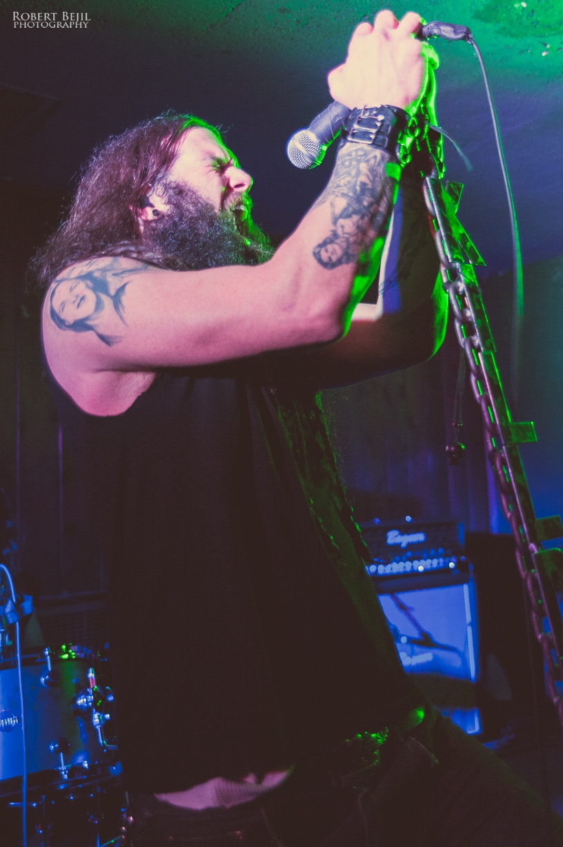 a man with long hair and tattoos holding a microphone up to his mouth