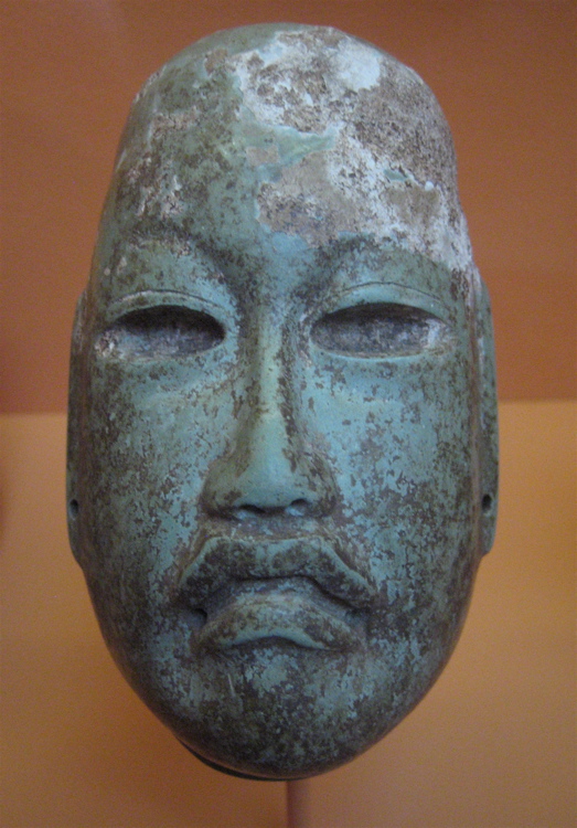 an old sculpture of a face with dirt on it