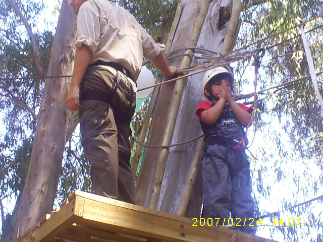 a man in a white hat is climbing on a high wooden platform