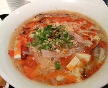 a bowl of chicken soup, served with rice and vegetables