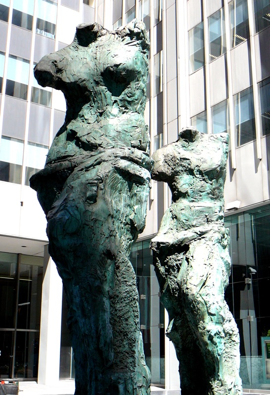 a statue is sitting on a sidewalk outside