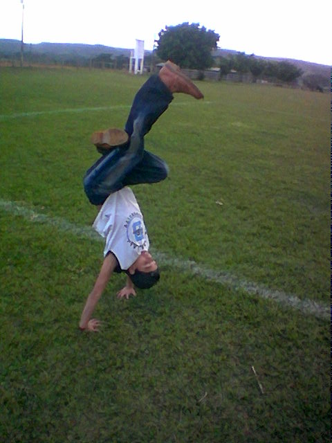 an image of a man doing a handstand on the grass