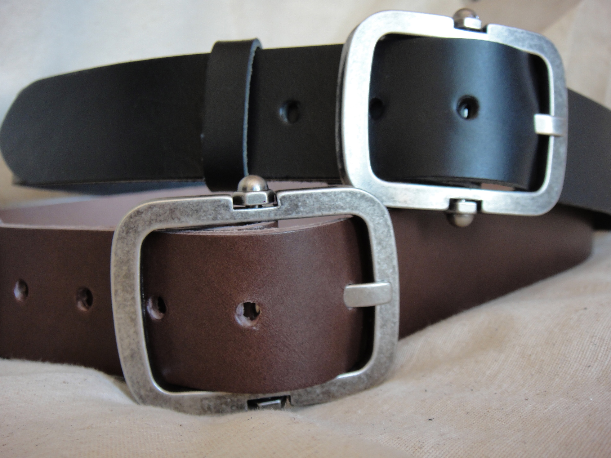 two belts, one with black and brown belting on it