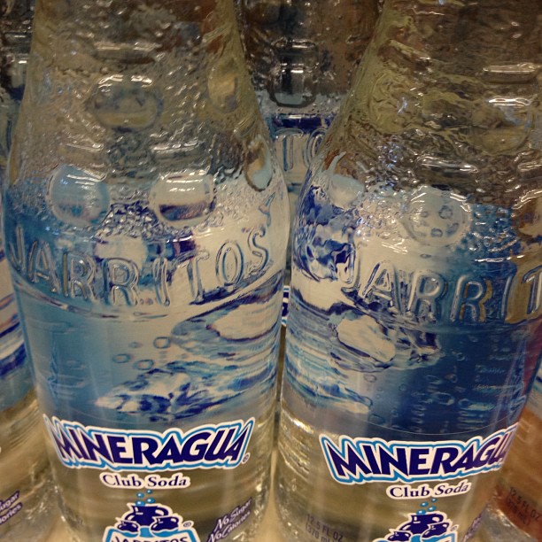 bottled mineral water lined up for sale in a grocery store