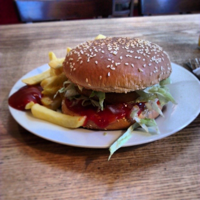 a burger and fries sit on a plate
