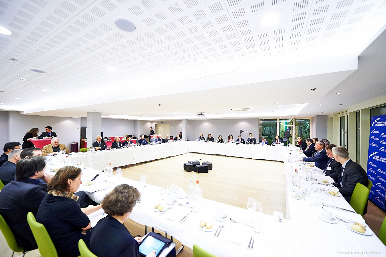 large conference hall full of people sitting at long tables