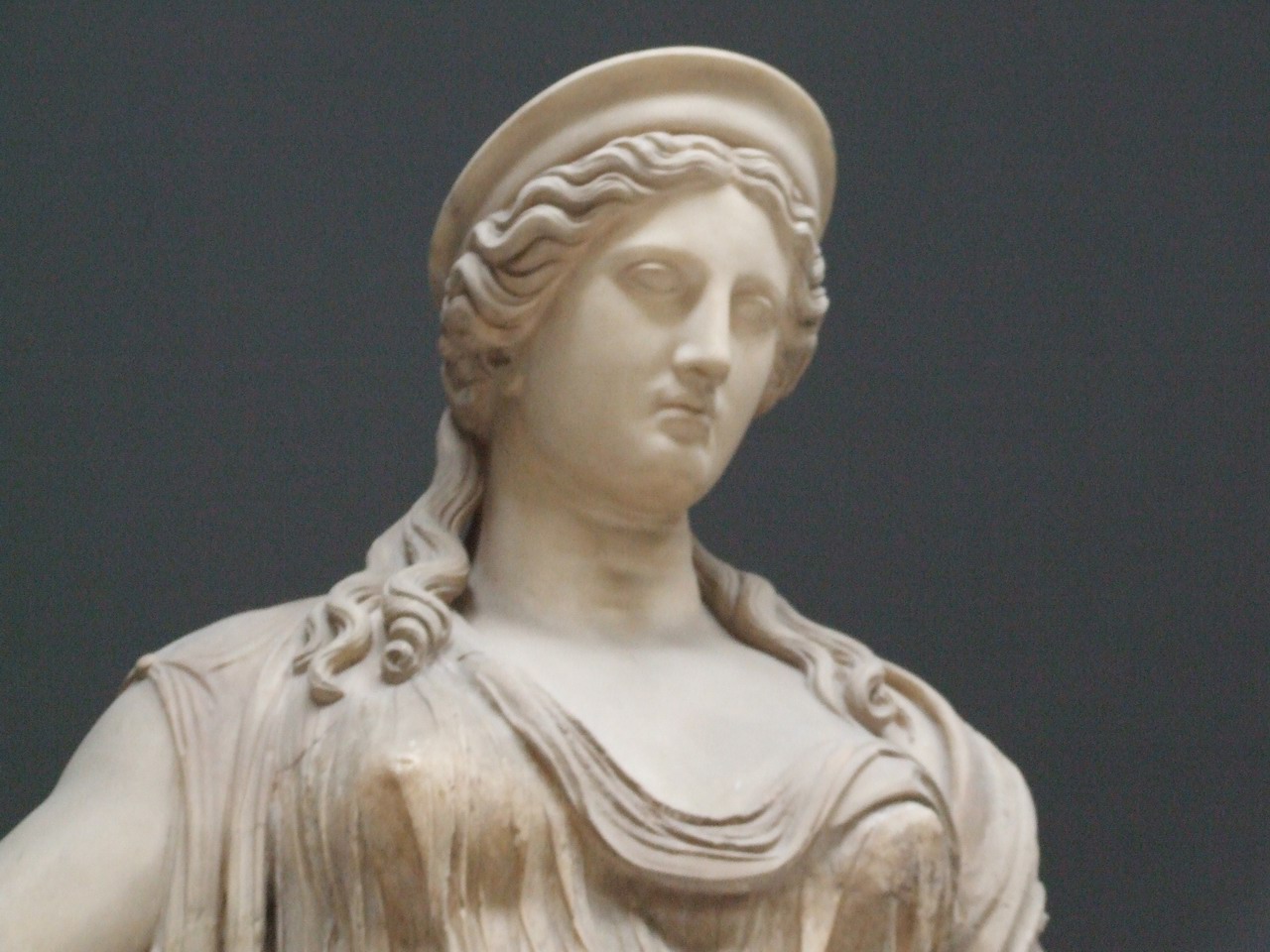 a statue of a woman in profile wearing a hat