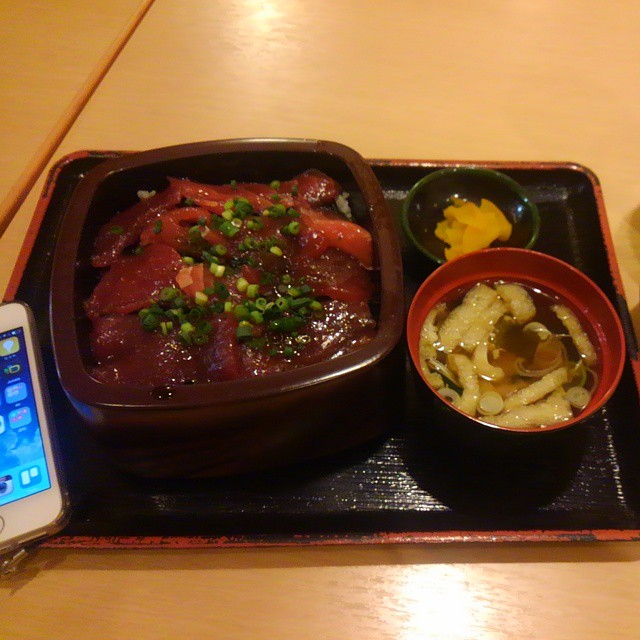 a brown tray topped with food next to a phone