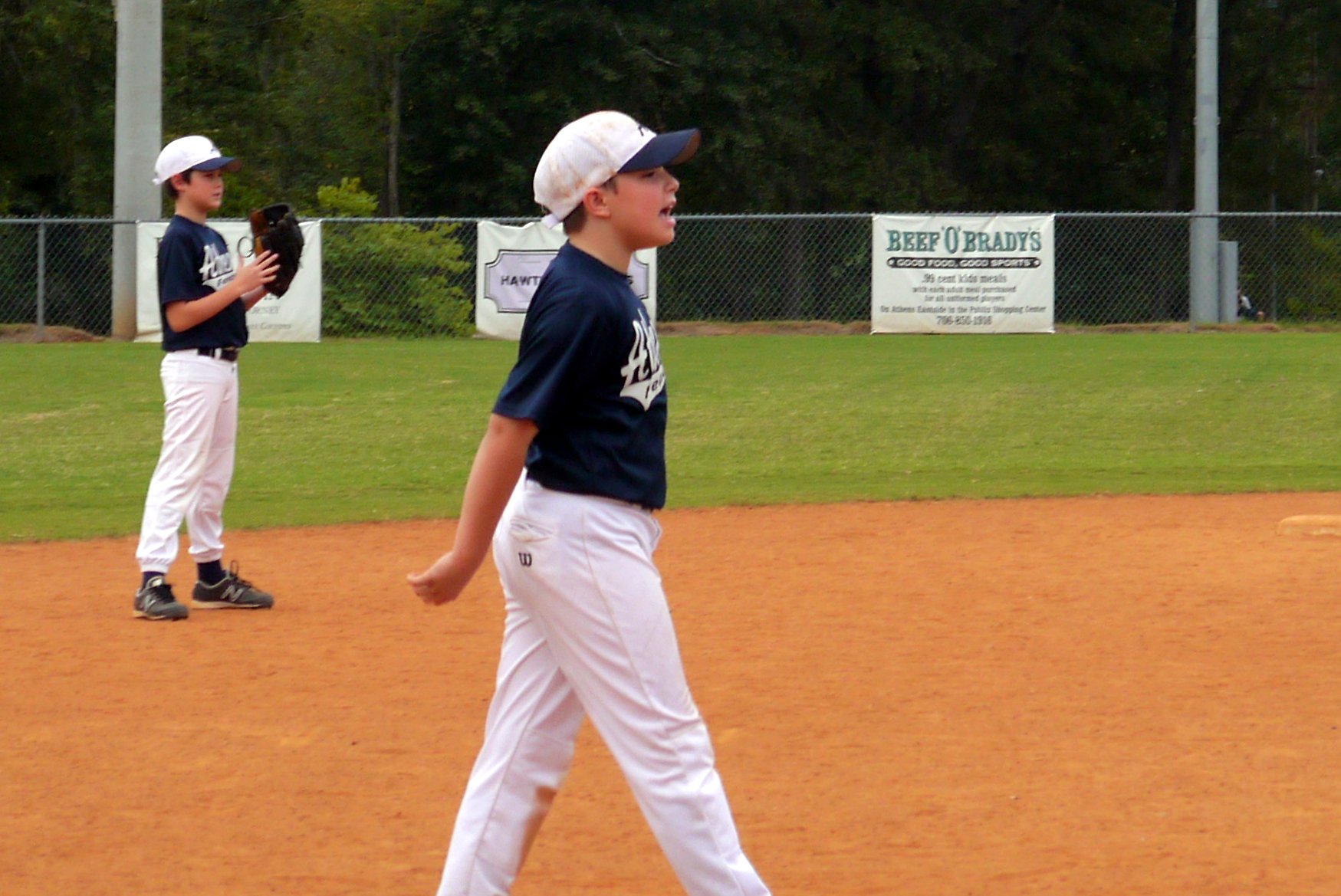 young children with baseball uniforms on at a field