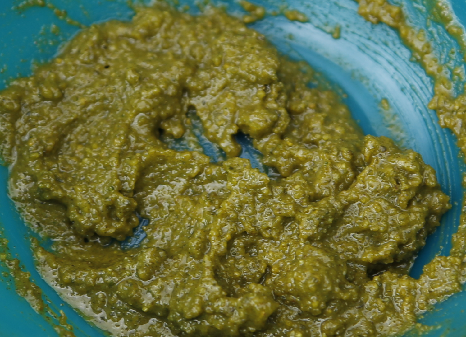 green food being made in a large blue bowl