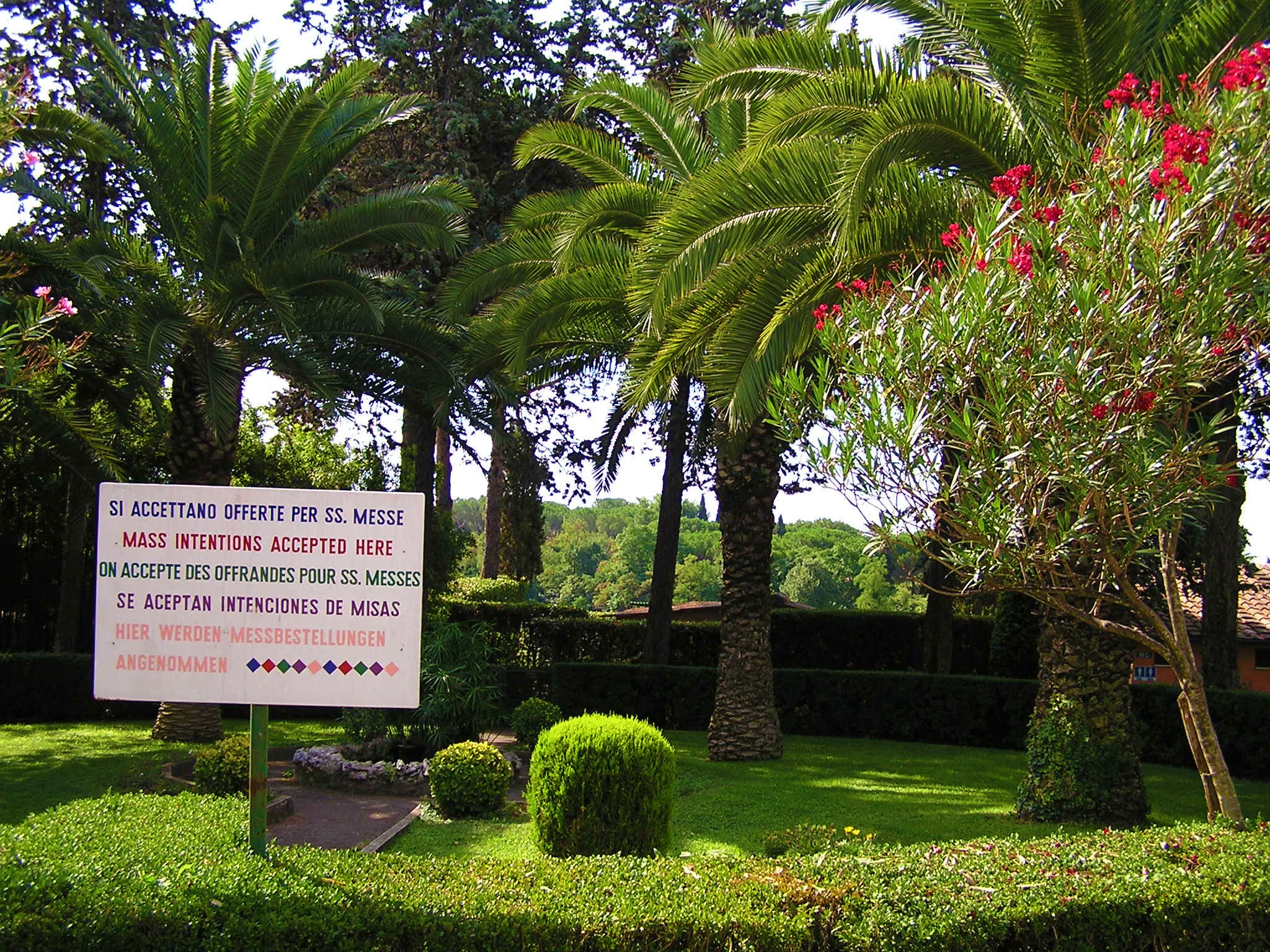 a garden with several trees and a sign in the center of it