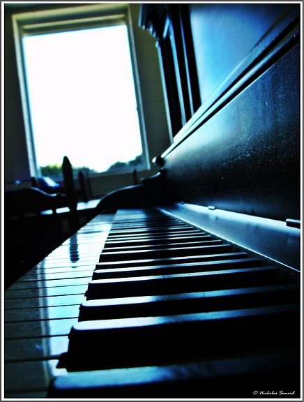 a piano is sitting by the window and a window sill