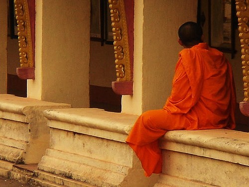 a man sitting outside a buddhist temple
