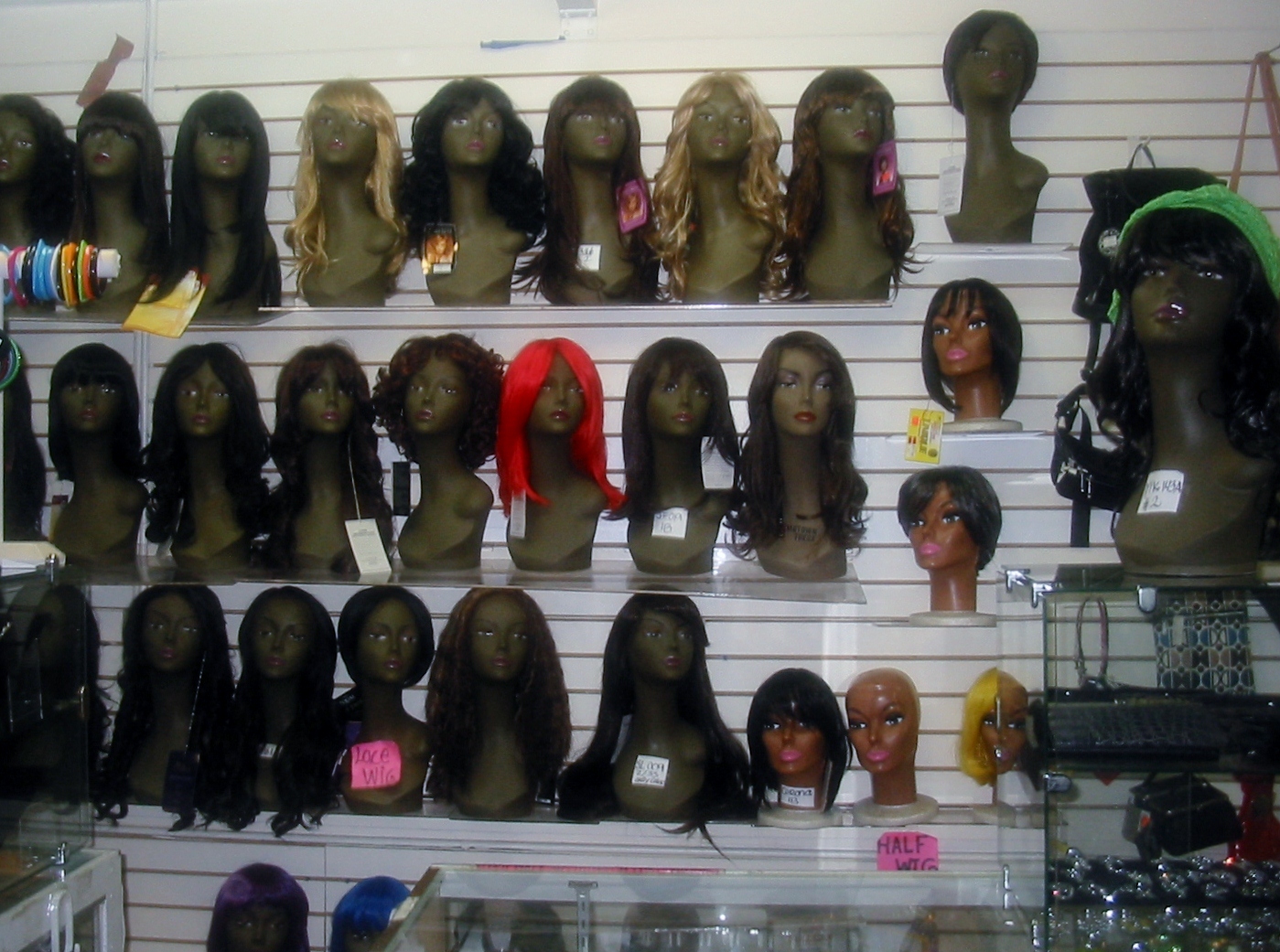 many wigs and hair styles on display in a shop